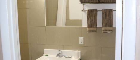 Un bagno con lavandino, specchio e water.