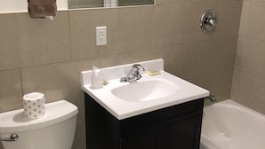 A bathroom with a toilet, sink, and bathtub. - Nights Inn (Thunder Bay)