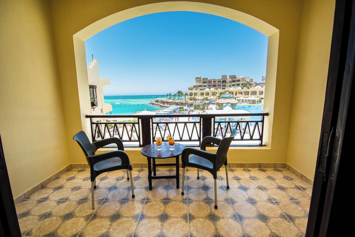 A balcony with a view of the sea and a resort.