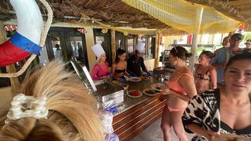 Un buffet avec différents plats et du personnel pour servir les clients.
