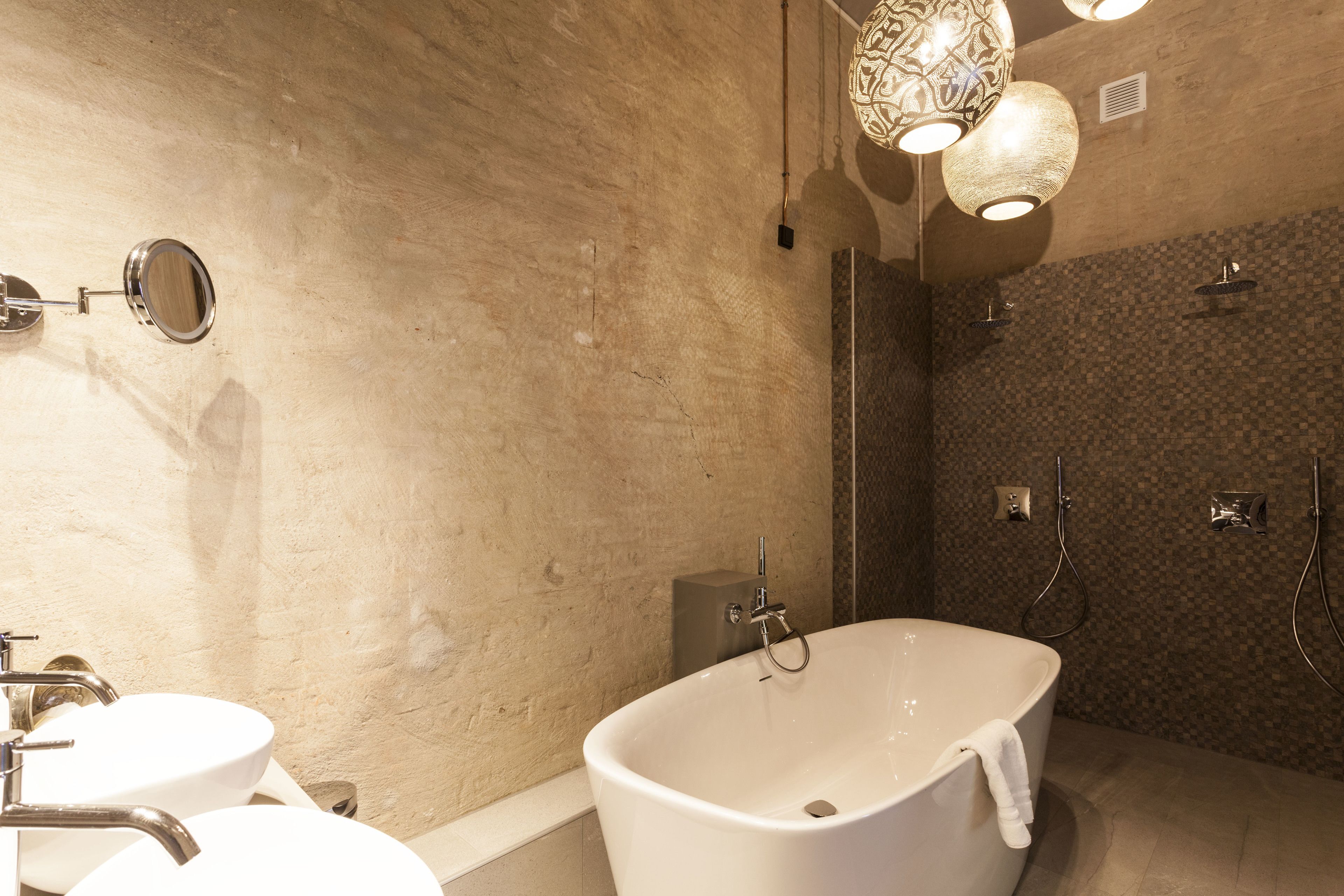 Un baño moderno con una bañera independiente, un lavabo doble y una ducha a pie.