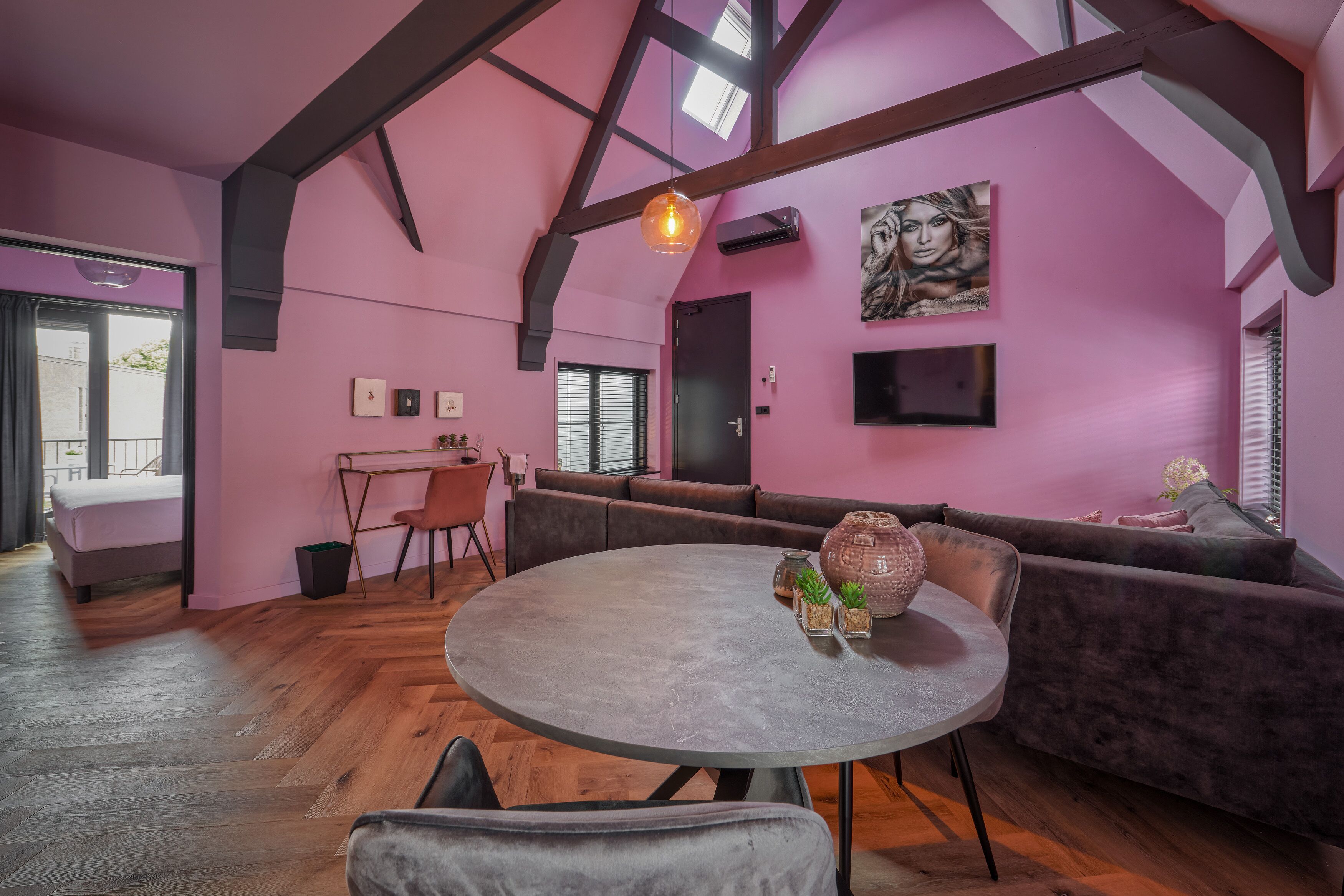 Een moderne woonkamer met een ronde tafel, een bank en een eethoek.
