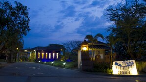 A hotel entrance with a sign, a well-lit building, and a clear sky. - Triumph Hotel (Mandalay)