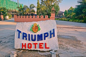 A stone sign with the words "TRIUMPH HOTEL" and a crest.