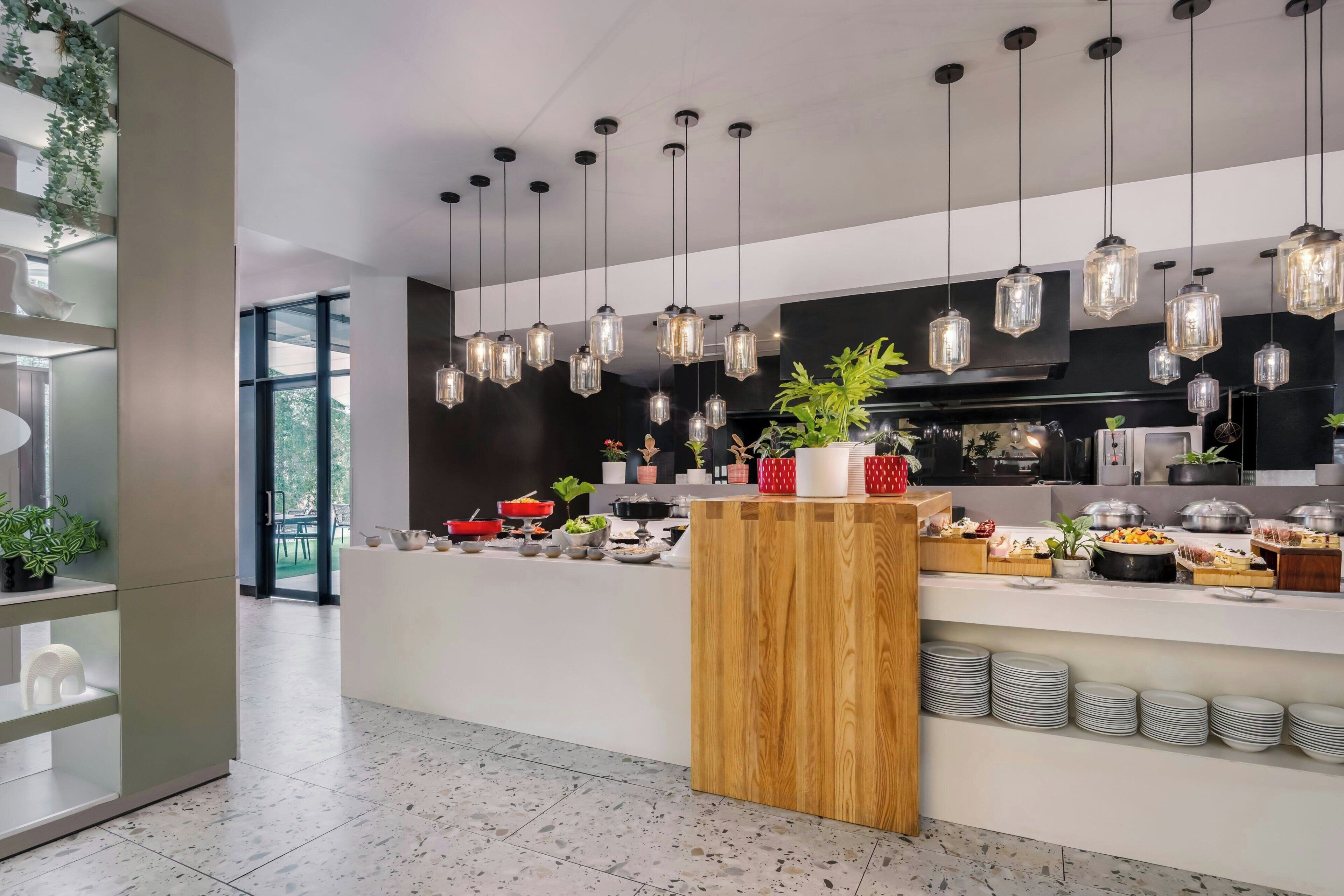Una cocina moderna con lámparas colgantes, una encimera de madera y diversos alimentos.