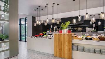 Una cocina moderna con lámparas colgantes, una encimera de madera y diversos alimentos.