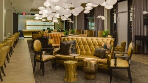 A modern lobby with a sofa set, chairs, and a reception desk. - Protea Hotel Fire & Ice by Marriott Pretoria Menlyn (Pretoria)