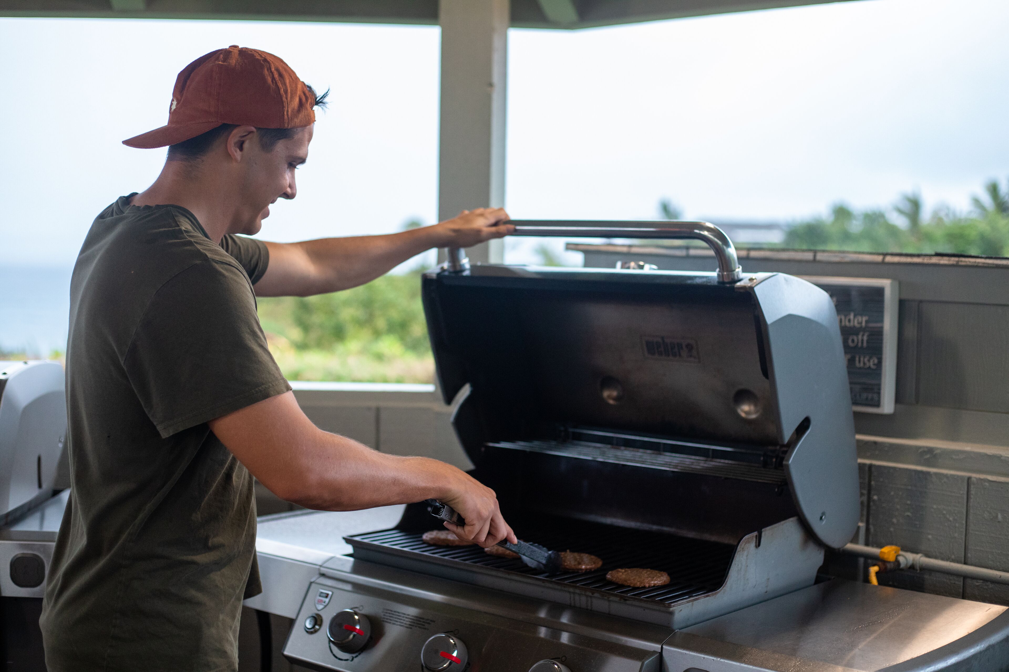 A person grilling burgers on an outdoor grill.