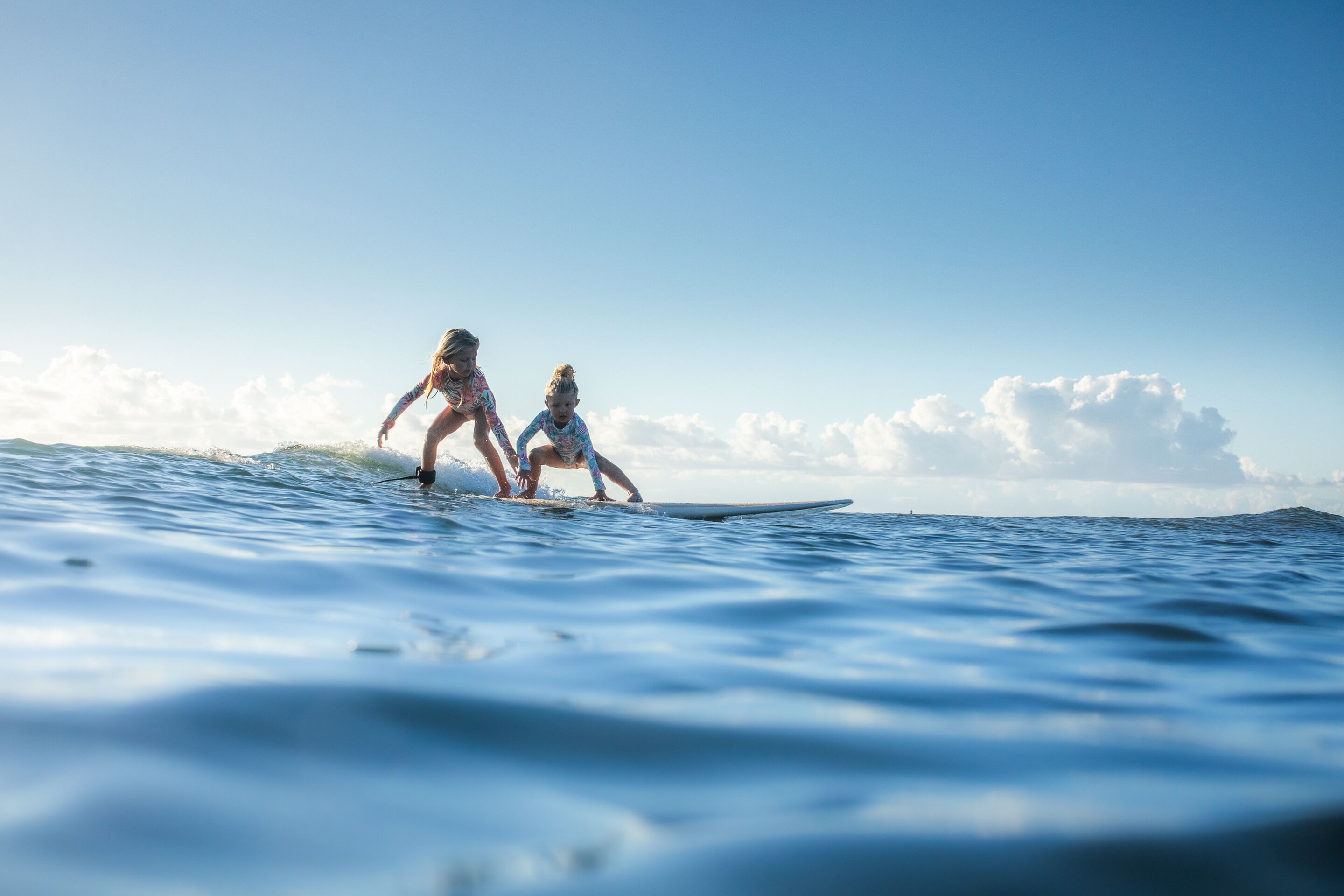 Due persone fanno surf su un'onda nell'oceano.