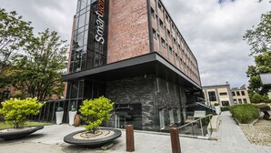 A modern building with a glass facade and a brick exterior. - Smart Hotel Garnizon (Gdansk)