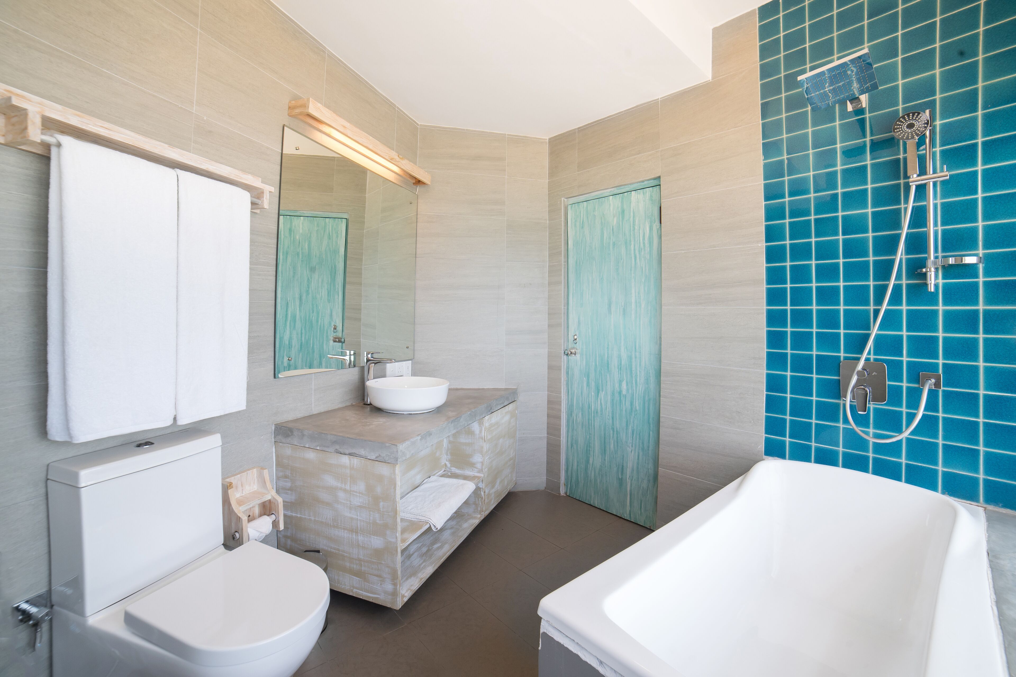 A modern bathroom with a toilet, sink, and bathtub.