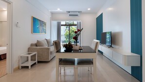 A modern living room with a dining table, sofa, and TV. - Ocean Sunrise Vung Tau (Ho Chi Minh City)