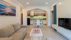 A modern living room with a sofa, a glass coffee table, and a TV on a stand. - Ocean Sunrise Vung Tau (Ho Chi Minh City)