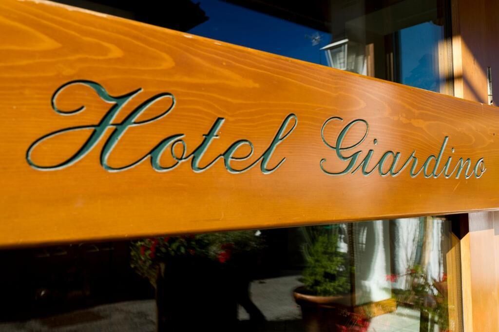 Ein Holzschild mit der Aufschrift 'Hotel Giardino'.