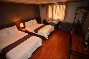 A hotel room with two beds, a desk, a chair, and a hanging coat rack. - Noblesse Tourist Hotel (Seoul)