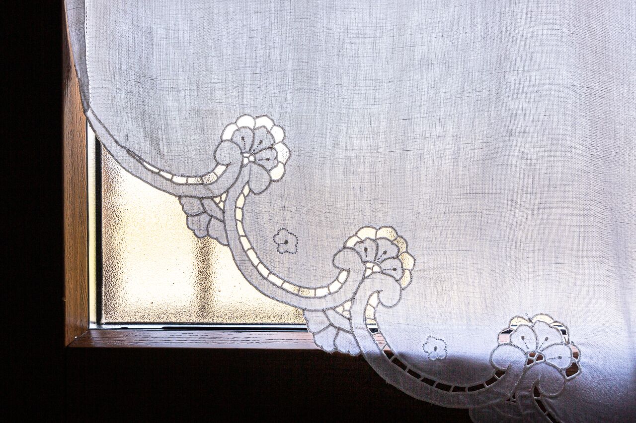 Una ventana con un diseño floral decorativo y una pequeña figura estilizada.