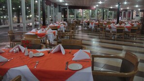 A restaurant with tables set for dining, featuring a checkered floor and large windows. - Nike Lake Resort (Enugu)