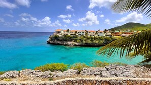 A coastal resort with multiple buildings on a rocky outcrop, overlooking turquoise waters. - Lagun Blou Resort (Lagun)