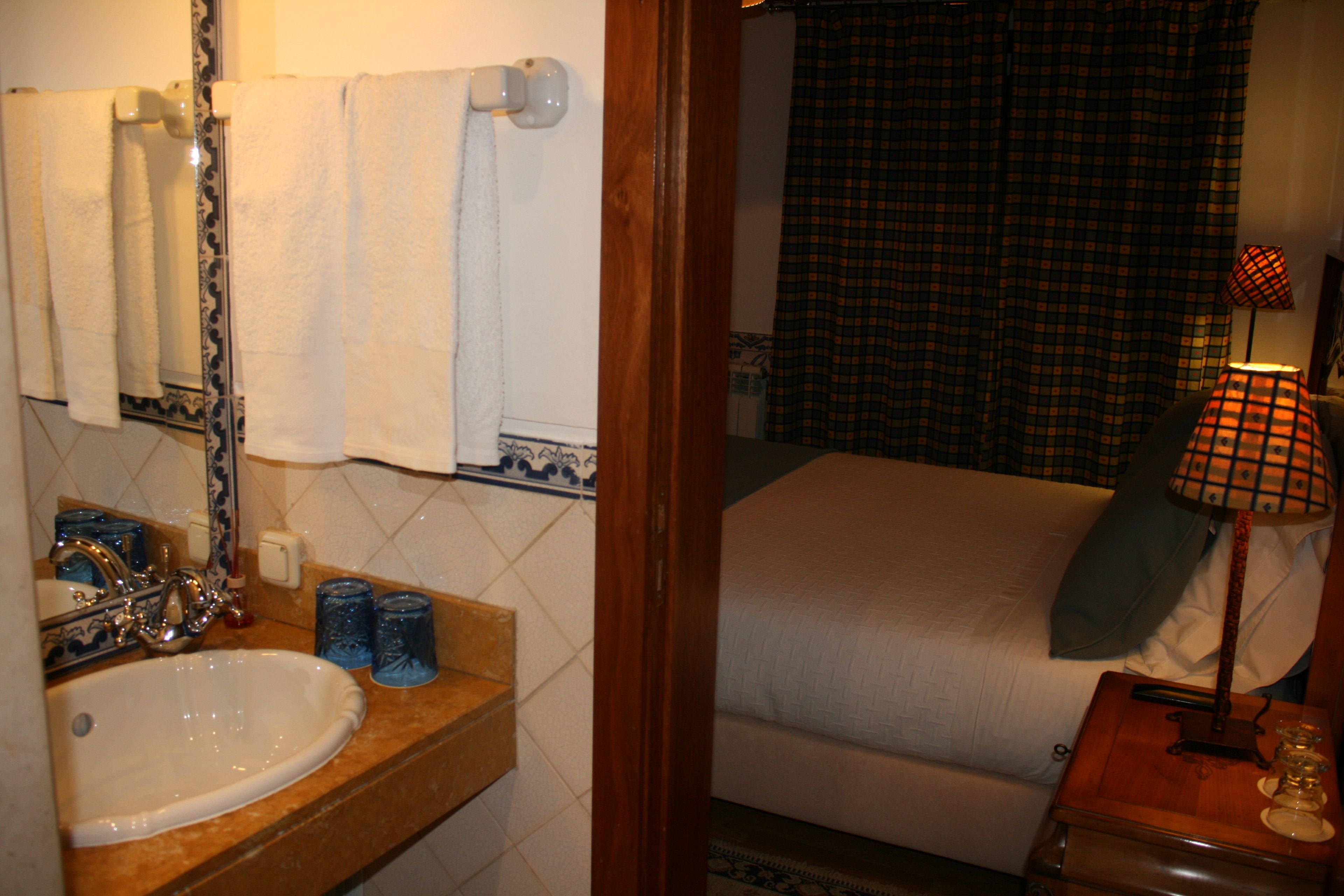 A bathroom with a sink, mirror, and towel rack.
