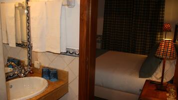 A bathroom with a sink, mirror, and towel rack.