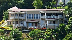 A multi-story house with balconies, surrounded by lush greenery. - Bayside Villa St. Lucia (Castries)