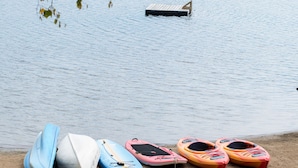 A calm lake with kayaks lined up on the shore. - Ogopogo Resort (Minden Hills)