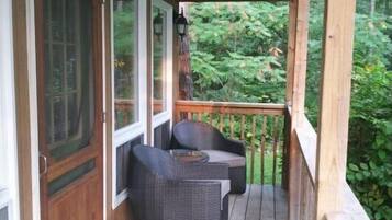 Relax on the covered porch with two comfortable chairs and a small table.