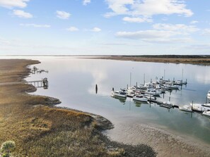 A marina with boats docked, a pier extending into the water, and a calm shoreline. - Regatta Inn Folly Beach (Folly Beach)