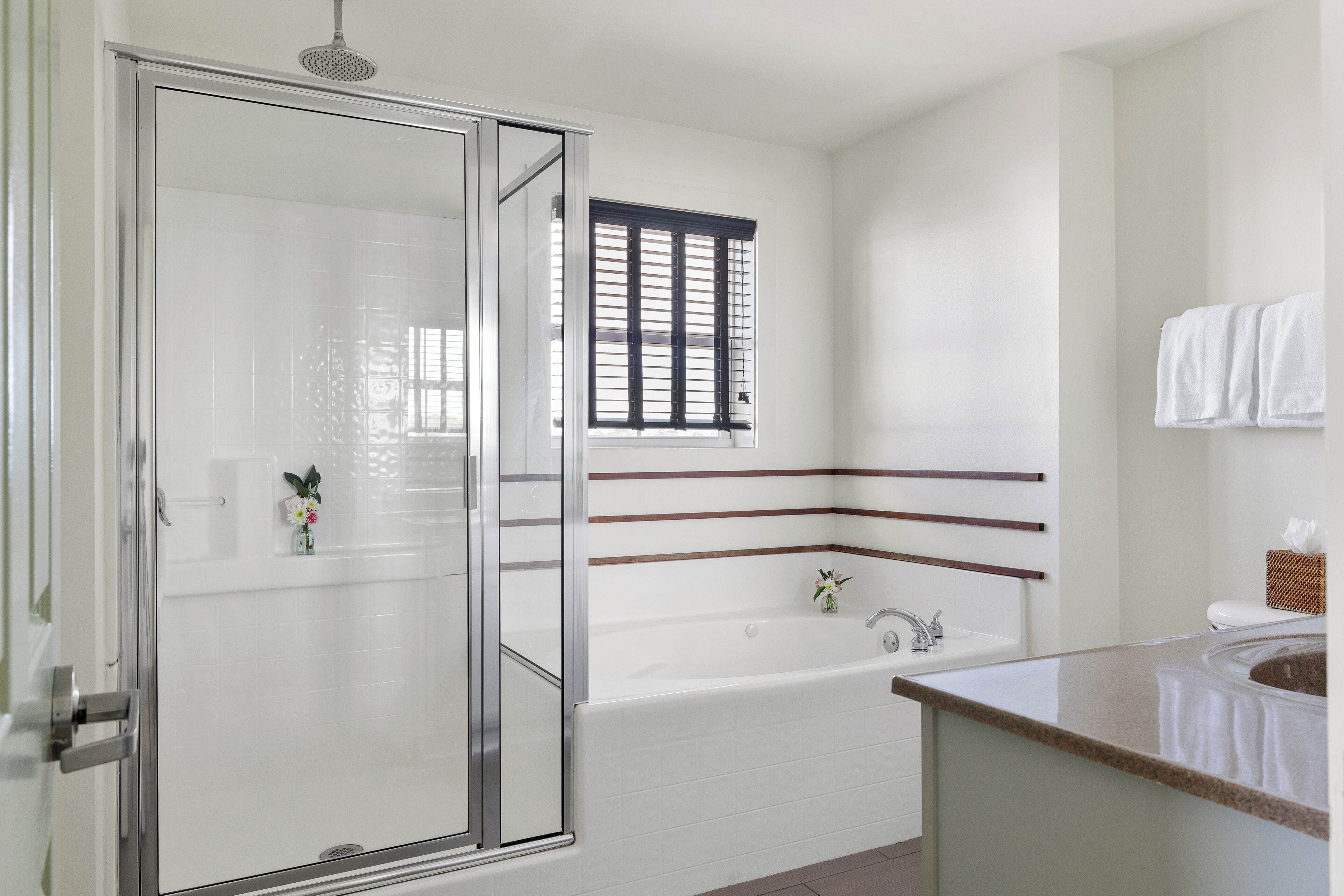 Een moderne badkamer met een douchecabine van glas, een vrijstaand bad en een wastafelmeubel met een wastafel.