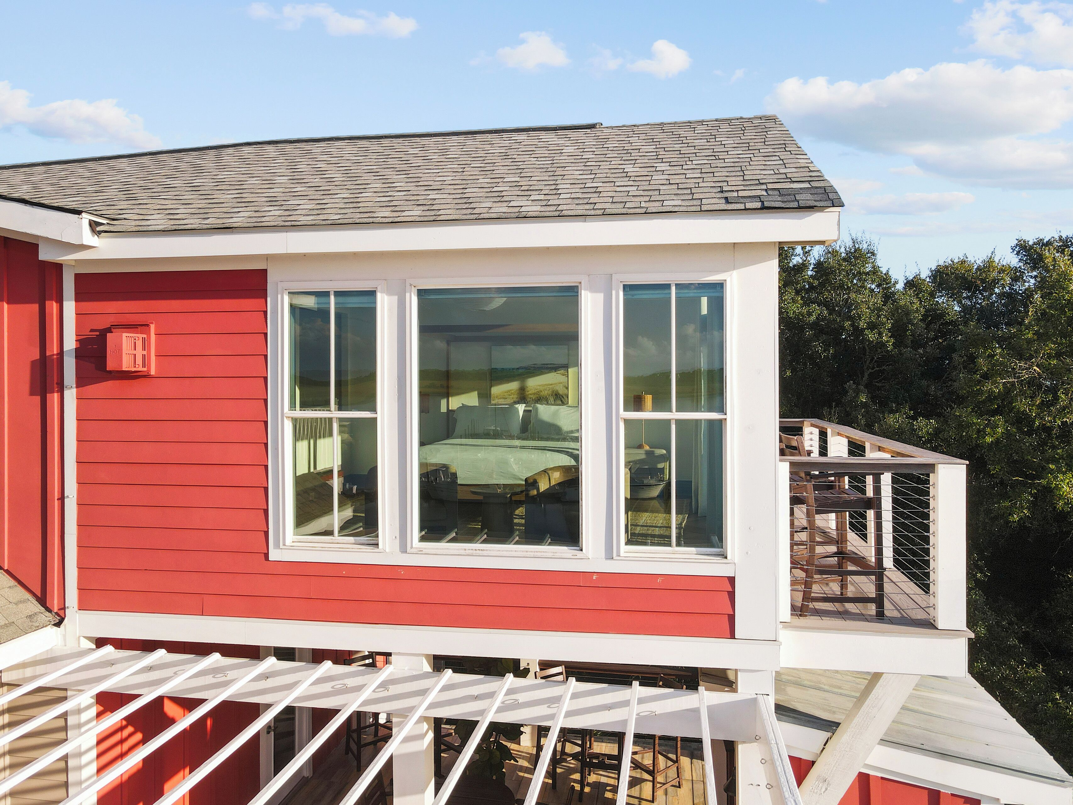 Een rood gebouw met een wit balkon en een groot raam.