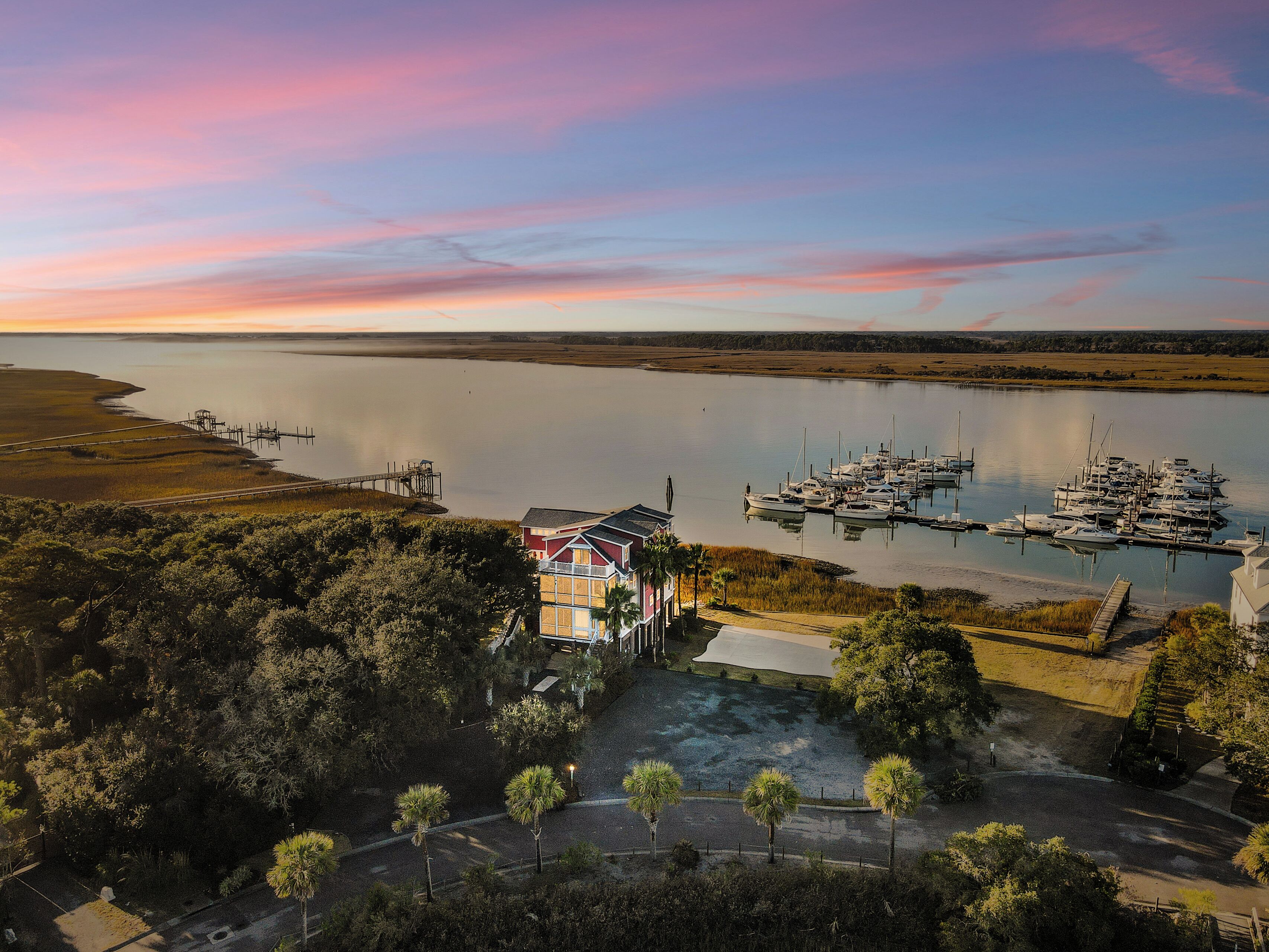 Une propriété située sur la côte, dotée d’un quai, d’une marina et d’une grande maison avec un balcon offrant une vue sur l’eau.
