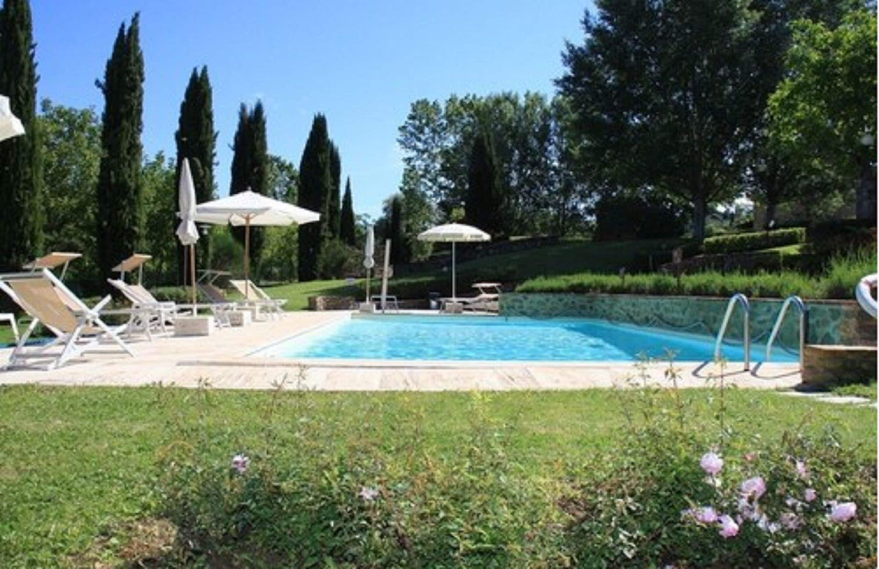 Una piscina al aire libre de temporada, sombrillas