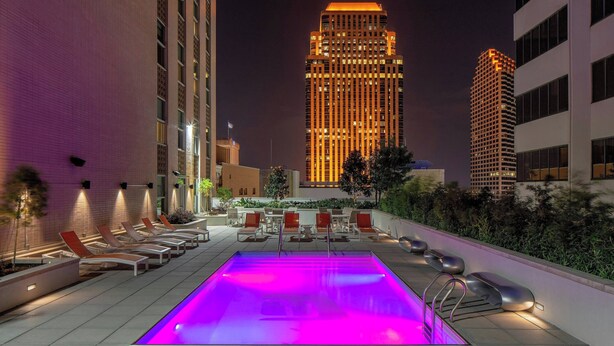 A rooftop pool with a view of tall buildings at night. - Aloft by Marriott New Orleans Downtown (New Orleans)