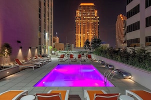 Una piscina al aire libre, sillones reclinables de piscina