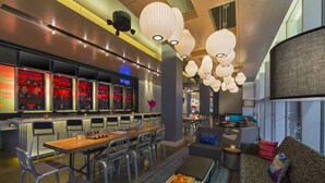 A modern hotel lobby with a bar area, seating arrangements, and decorative lighting. - Aloft by Marriott New Orleans Downtown (New Orleans)