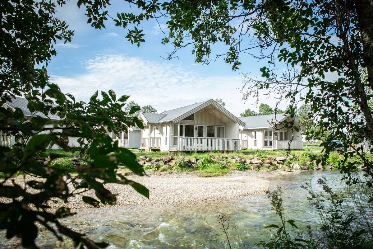 Ein Haus mit Veranda und einem Fluss davor.