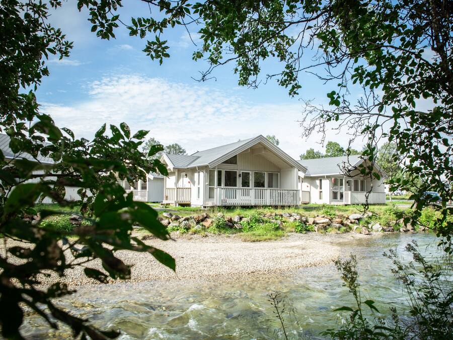 A house with a porch and a river in front.