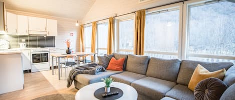 Una sala moderna con un sofá, una mesa de centro y un comedor con una mesa y sillas.
