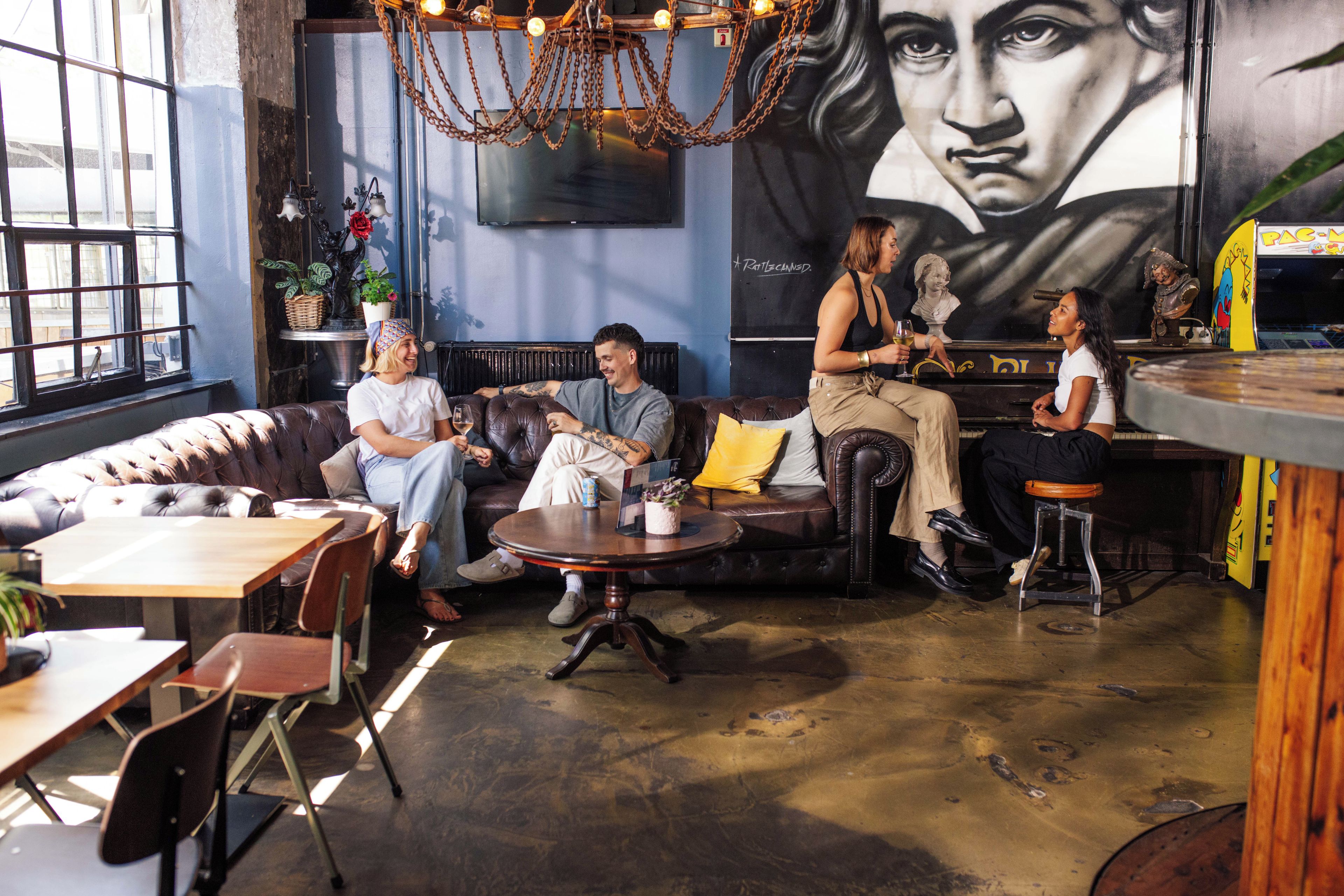 Un área de descanso con sofás de cuero, un bar y un mural en la pared.