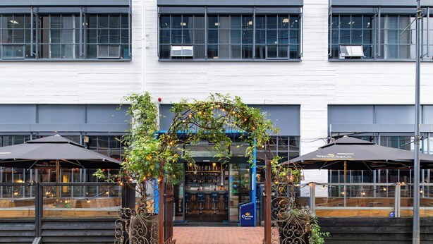 A building with a bar area, outdoor seating, and a covered entrance. - Stayokay Eindhoven - Hostel (Eindhoven)