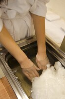 Una persona lava las manos en un lavabo lleno de espuma de jabón.