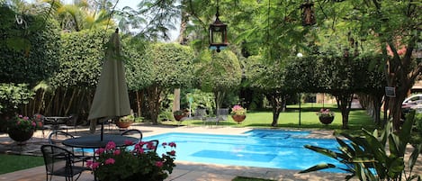 Een buitenzwembad, parasols voor strand/zwembad