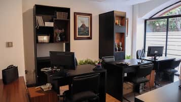 A modern office with desks, chairs, and shelves containing books and decorative items.