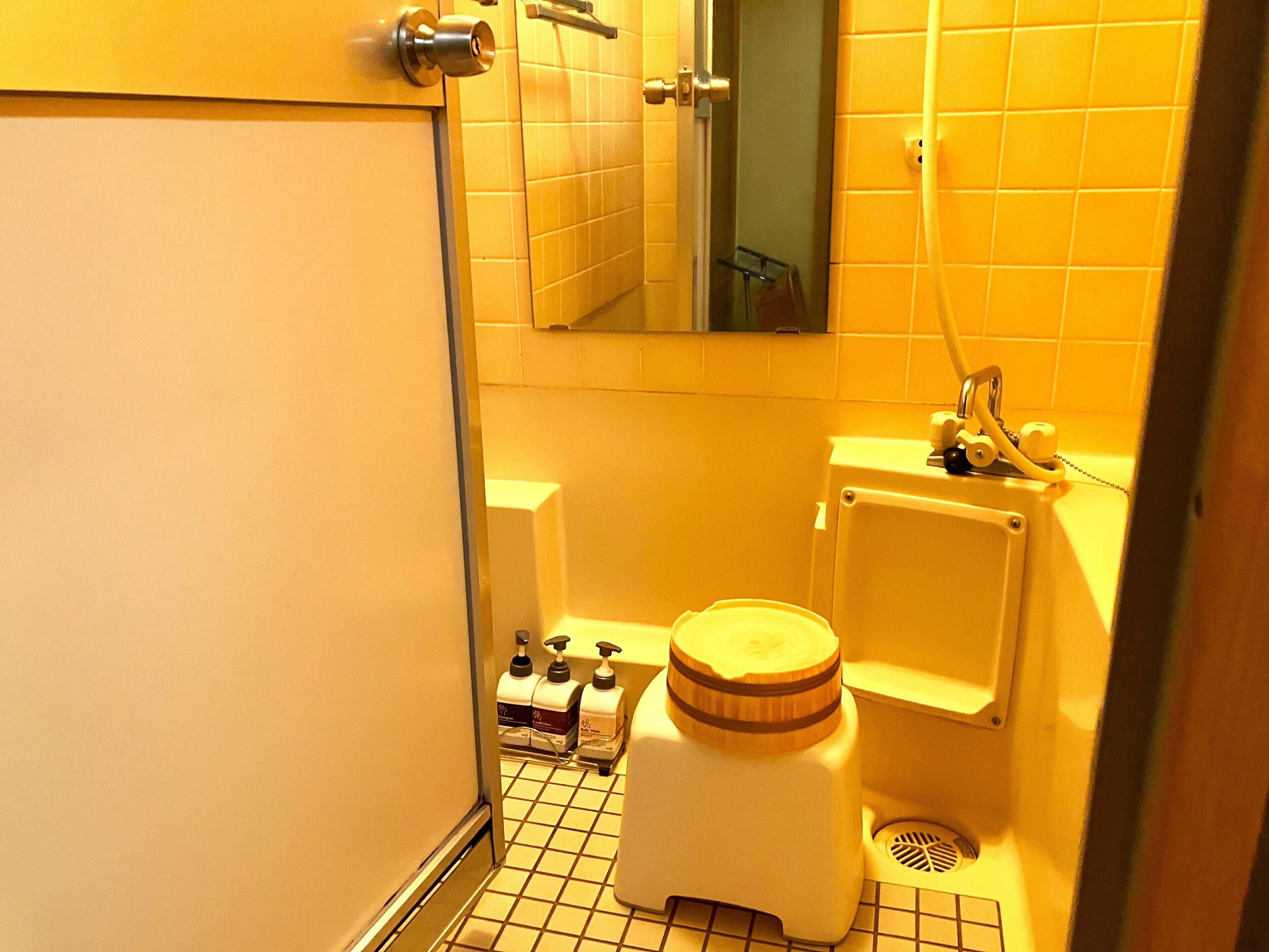 A small, compact bathroom with a toilet, a sink, and a mirror.