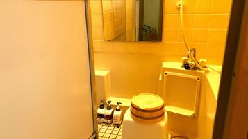 A small, compact bathroom with a toilet, a sink, and a mirror.