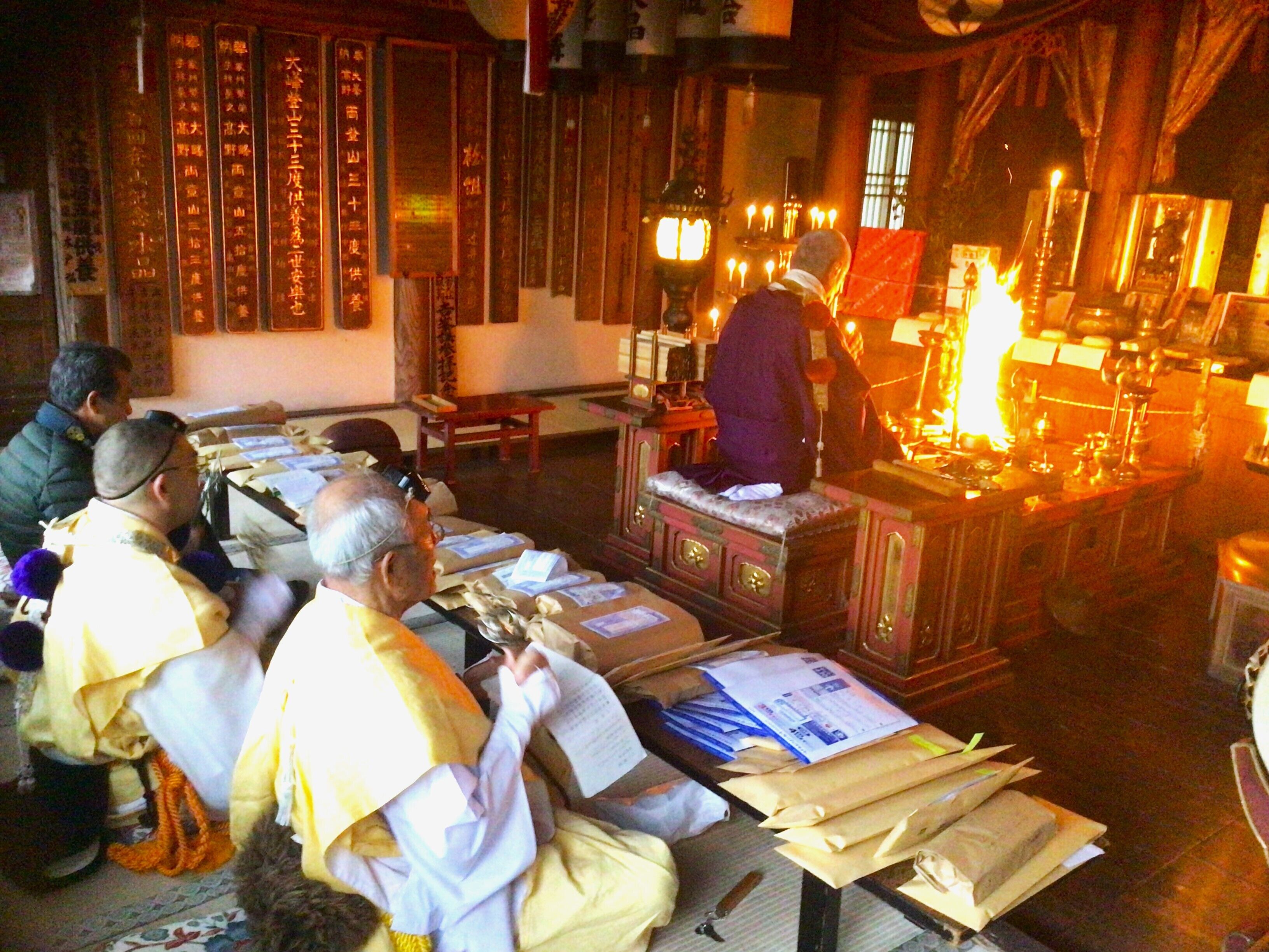 Una habitación tradicional con muebles de madera, una mesa central con papeles y una lámpara encendida.