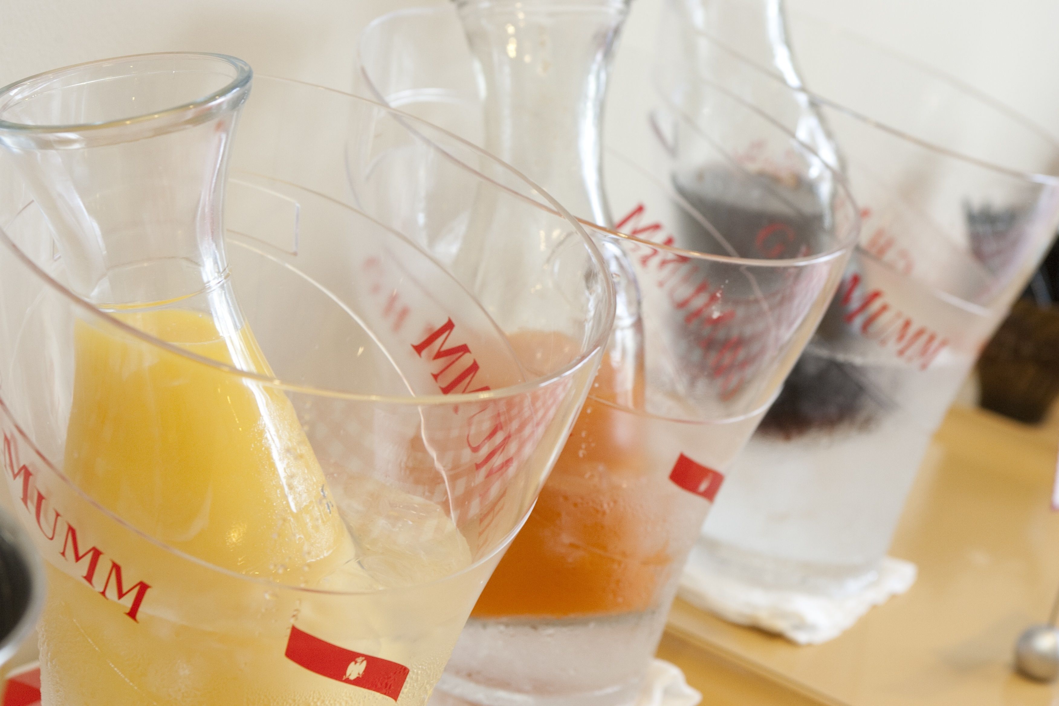 A series of measuring cups with different colored liquids.