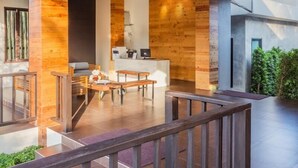 A modern interior with a wooden accent wall, a reception desk, and a seating area with a view to the outdoors. - Lipda Resort (Prachuap Khiri Khan)