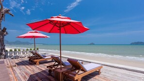 位於海灘上、躺椅、遮陽傘、海灘浴巾