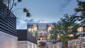 A modern building with a central staircase, stone walls, and a pathway. - Lipda Resort (Prachuap Khiri Khan)